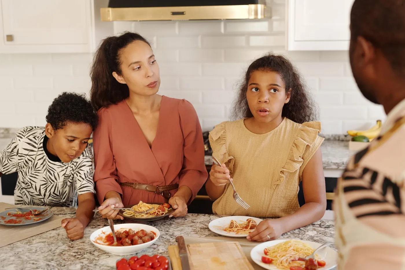 A family sharing a meal together around the kitchen table.